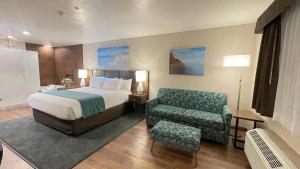 a hotel room with a bed and a chair at Old Town Inn in San Diego