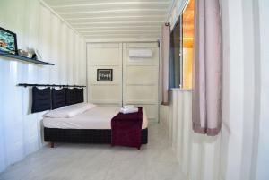 a small bedroom with a bed and a window at Contêiner Exclusivo - Praia da Gamboa - GAR002 in Gamboa
