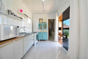 a kitchen with white cabinets and blue appliances at Contêiner Exclusivo - Praia da Gamboa - GAR002 in Gamboa