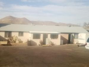 una casa blanca con montañas al fondo en BV Motel LLC, en Searchlight
