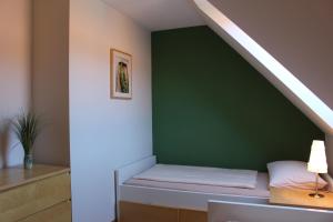 Bett in einem Zimmer mit grüner Wand in der Unterkunft Bauernhof Höpner "Im Backhaus" in Vadersdorf