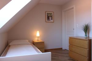 ein Schlafzimmer mit einem Bett und einer Lampe auf einer Kommode in der Unterkunft Bauernhof Höpner "Im Backhaus" in Vadersdorf