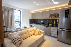 a living room with a couch in a kitchen at Move #914 - Apartamento Confortável by Carpediem in Tambaú