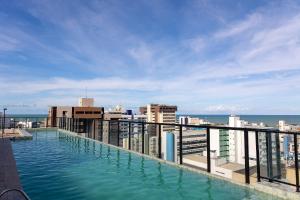 a swimming pool on the roof of a building at Move #914 - Apartamento Confortável by Carpediem in Tambaú