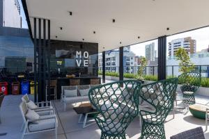 a patio with chairs and tables on a building at Move #914 - Apartamento Confortável by Carpediem in Tambaú