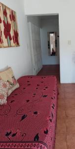 Un dormitorio con una cama con un edredón rojo. en Depto Sierra, en Santa Rosa de Calamuchita