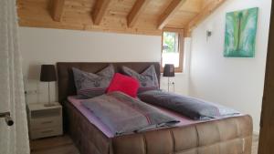 a bed with pillows on it in a room at Ferienhaus Casa Rosa - LienzOsttirol in Leisach