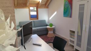 a living room with a couch and a desk with a computer at Ferienhaus Casa Rosa - LienzOsttirol in Leisach