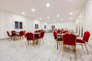 a dining room with red chairs and tables at Capital O Che Sigma Hotel in Hyderabad +45 photos