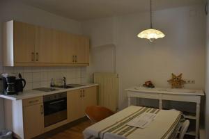 a kitchen with wooden cabinets and a table and a light at Wohnung Richtung bischöflichen Sitz in Graz