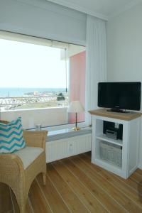 een woonkamer met een flatscreen-tv en een raam bij STRANDIDYLL, 58 - Typ A1S in Grömitz