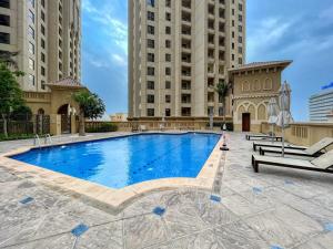 a large swimming pool with two tall buildings at Luxurious Brand New 2BR Apartment in Rimal 1 I Steps to the JBR Beach I GYL Holiday Homes in Dubai