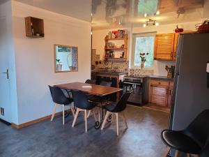 a kitchen with a wooden table and chairs at Maison avec Jardin en bord de rivière in Fresnay-sur-Sarthe