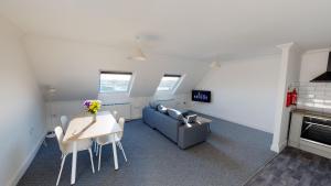 ein Wohnzimmer mit Sofa, Tisch und Stühlen in der Unterkunft K Suites - Bridge Apartments in Lowestoft