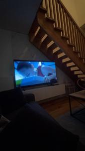 sala de estar con TV y escalera en Apartman Kenan, en Bjelašnica