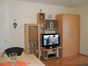 a living room with a television and a book shelf at Fewo 91 WHG B 18 in Burhave in Burhave
