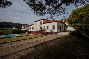 a white house with a pool in front of it at Casa da Ponte de Mucela in Vila Nova de Poiares