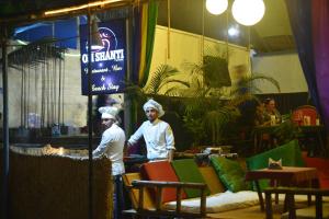 dwóch kucharzy stojących w pokoju ze stołami i krzesłami w obiekcie Om Shanti Beach Stay Patnem w mieście Patnem