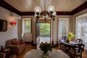 a living room with a table and a chandelier at Casa da Ponte de Mucela in Vila Nova de Poiares