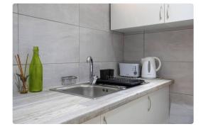 a kitchen counter top with a sink and a mixer at BeGuest Casetta Cleo in Páteo