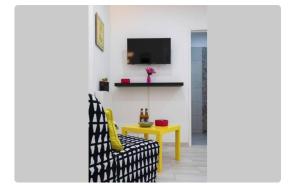 a living room with a yellow table and a yellow chair at BeGuest Casetta Cleo in Páteo