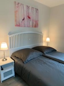 a bedroom with a bed with two lamps and a painting at Ferienwohnung 2404 App 6 in Burhave in Burhave