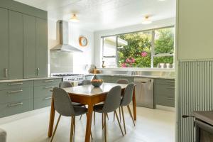 a kitchen with a wooden table and chairs at Cliffscapes in Punakaiki