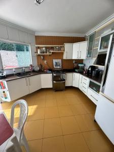 eine Küche mit weißen Schränken und Fliesenboden in der Unterkunft Casa Belém COP30 5 quartos in Belém
