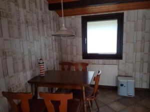 a dining room with a table and chairs and a window at Bungalow M 43 in Burhave in Burhave