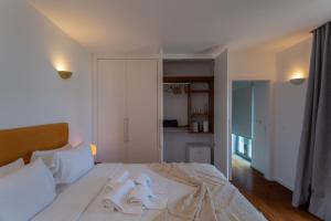a bedroom with a large white bed with white pillows at Penedo Escape Sea Suites in Colares