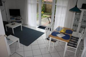 a living room with a table and chairs and a television at Ferienwohnung 1066 App 3 in Tossens in Stick +17 photos