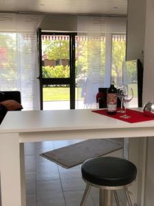 a kitchen with a counter with wine glasses and a stool at Ferienhaus 251 in Burhave in Hoddersdeich +12 photos