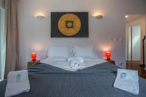 a bedroom with a large bed with towels on it at Penedo Escape Sea Suites in Colares