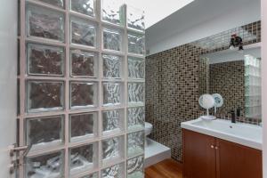 a bathroom with a wall of glass blocks at Penedo Escape Sea Suites in Colares