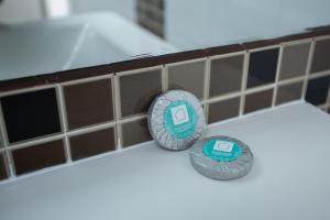 two stickers on a bathroom tiled wall at Penedo Escape Sea Suites in Colares