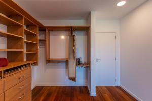 a kitchen with white walls and wooden cabinets at Penedo Escape Sea Suites in Colares