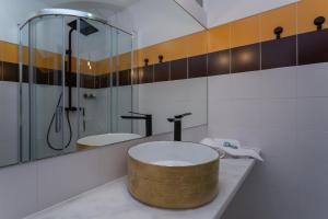 a bathroom with a round sink and a shower at Penedo Escape Sea Suites in Colares
