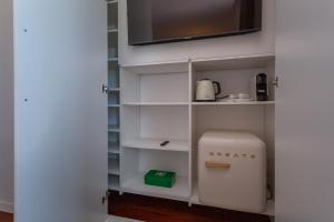 a room with a white pantry with a small appliance at Penedo Escape Sea Suites in Colares