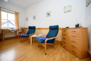 a room with two chairs and a desk and a dresser at Strandnelke in Graal-Müritz