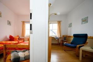 a bedroom with a bed and a blue chair in it at Strandnelke in Graal-Müritz +17 photos