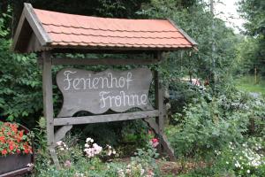 a sign in a garden with a roof at Ferienhof Frohne - Zum wilden Eber in Merzen