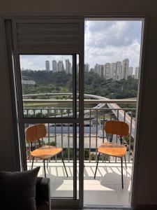 a balcony with two chairs and a view of a city at Laguna 380 in Sao Paulo