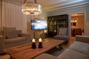 a living room with a table and a tv at La Faya "Molerhüsli"- Gemütliches, gehobenes Ferienhaus in Muggenbrunn -Feldberg in Muggenbrunn