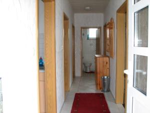 a hallway of a bathroom with a toilet and a sink at Hering in Grossenbrode +2 photos