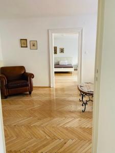 グラーツにあるWohnung, 3 Zimmer, eines davon Durchgangszimmer, ruhig, Graz Zentrumのリビングルーム(椅子、鏡付)