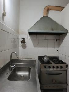 a kitchen with a stove and a sink in it at Hostel Downtown Las Morenas in Buenos Aires +37 photos