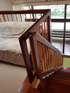 史代比兹Appartement Nr 11, Oberstaufen-Steibis, Allgäu, Oberstaufen PLUS的木楼梯,带床和窗户的房间