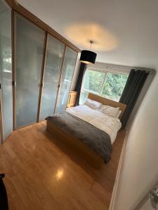a bedroom with a bed and a large window at Charming Flat in North London in Edmonton +5 photos