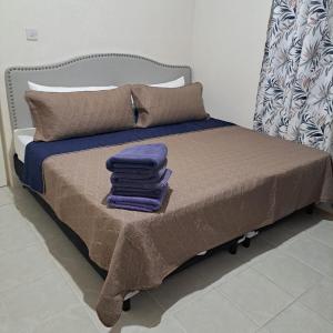 a bed with a pile of towels on it at Uthelina in Saint Peter