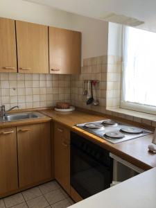 une petite cuisine avec une cuisinière et un évier dans l'établissement To Hus, Reihenhaus 7, à Kellenhusen